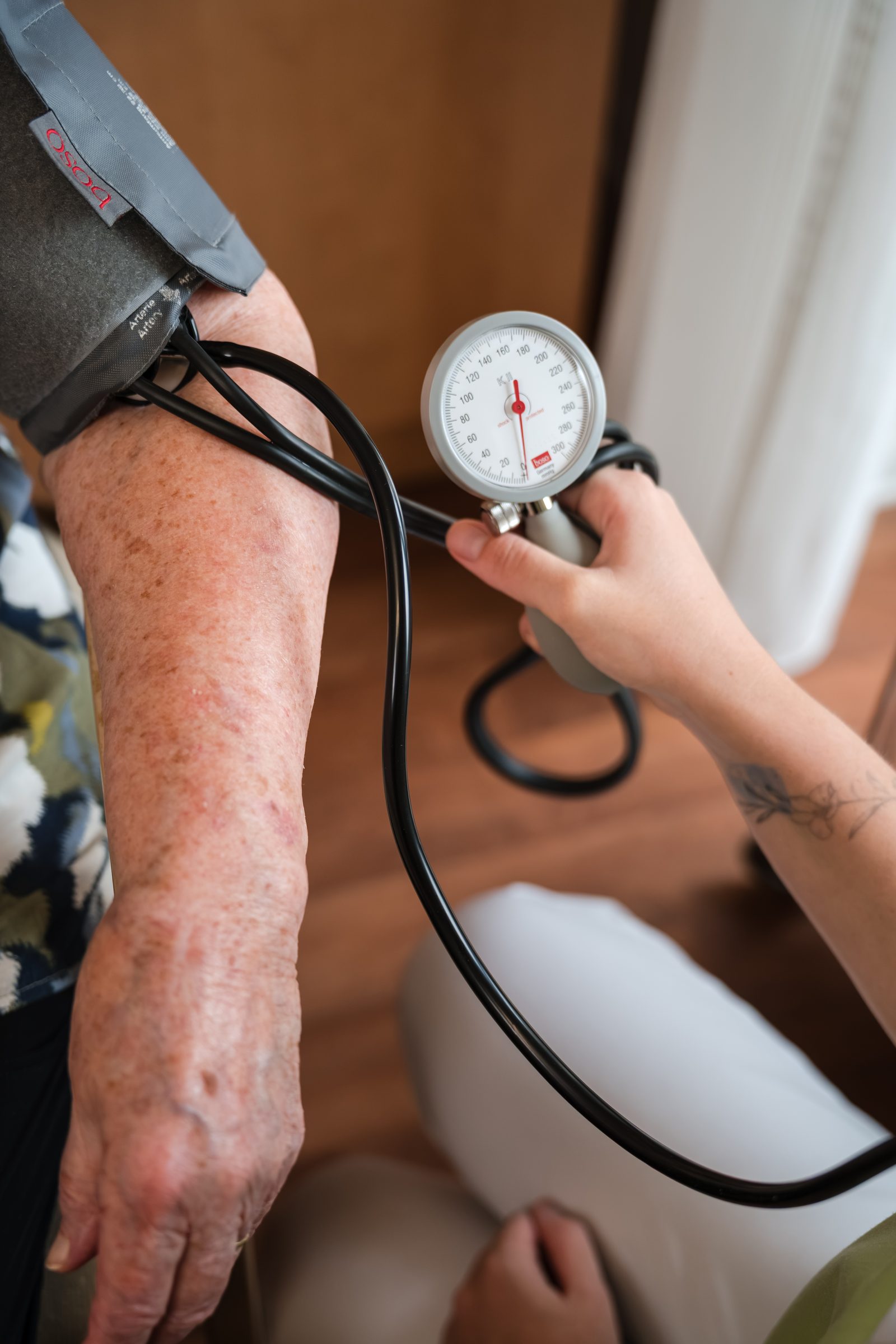 Nahaufnahme einer Blutdruckmessung am Arm einer Bewohnerin