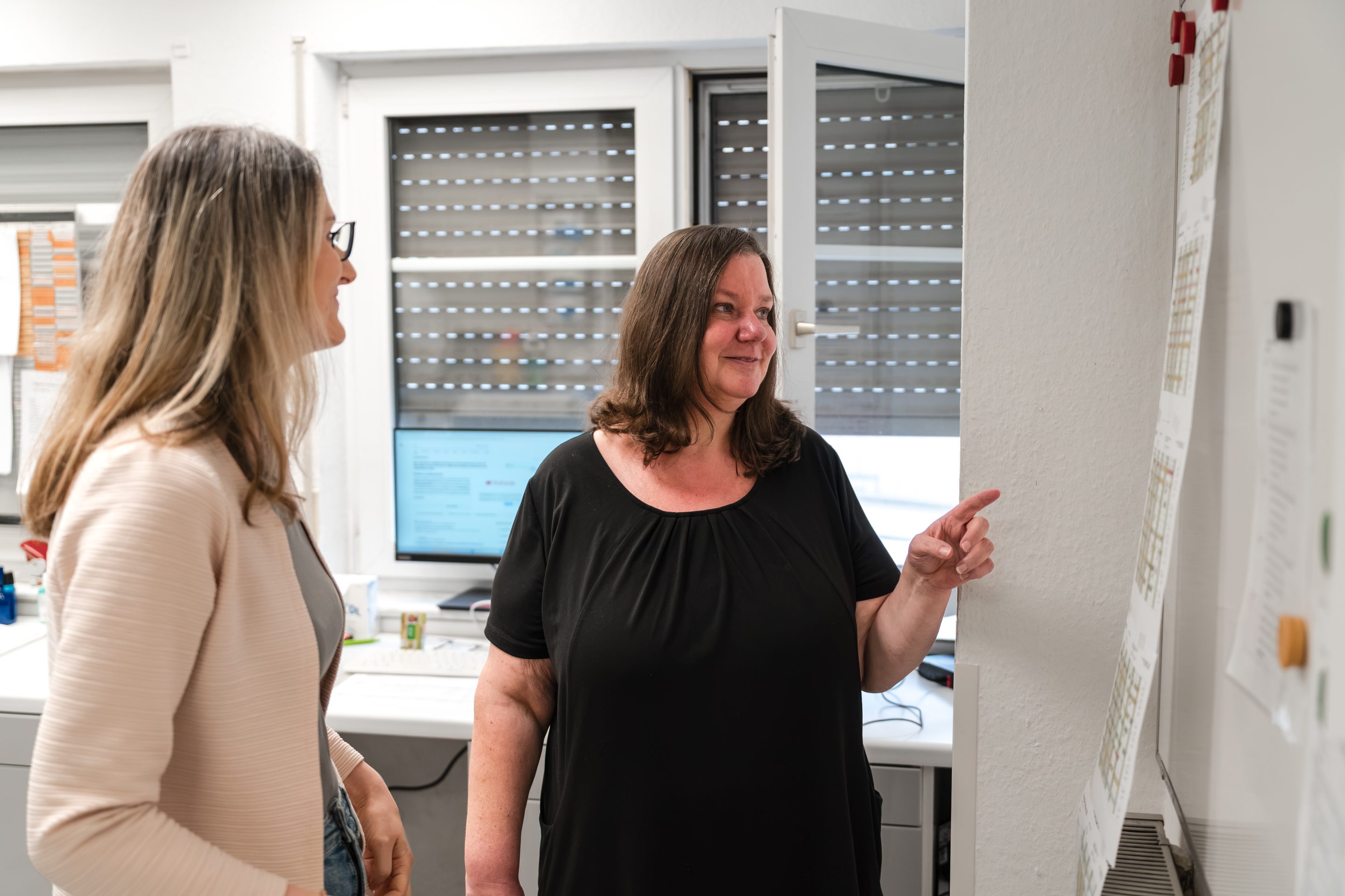 Zwei Mitarbeiterinnen im Gespräch im Büro
